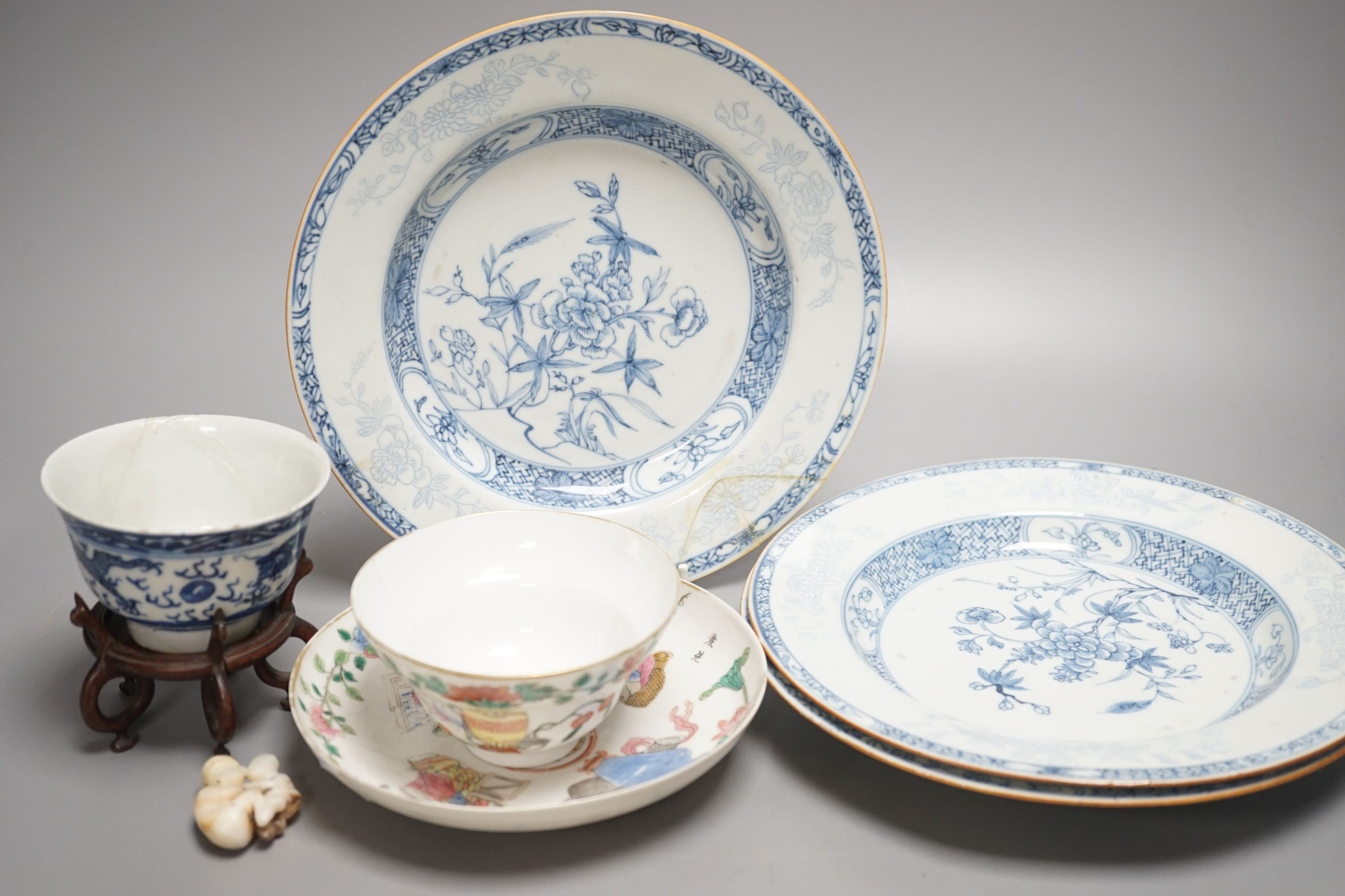 A 19th century Chinese famille rose bowl and saucer, a blue and white tea bowl on stand, a hardstone carving and three 18th century blue and white plates